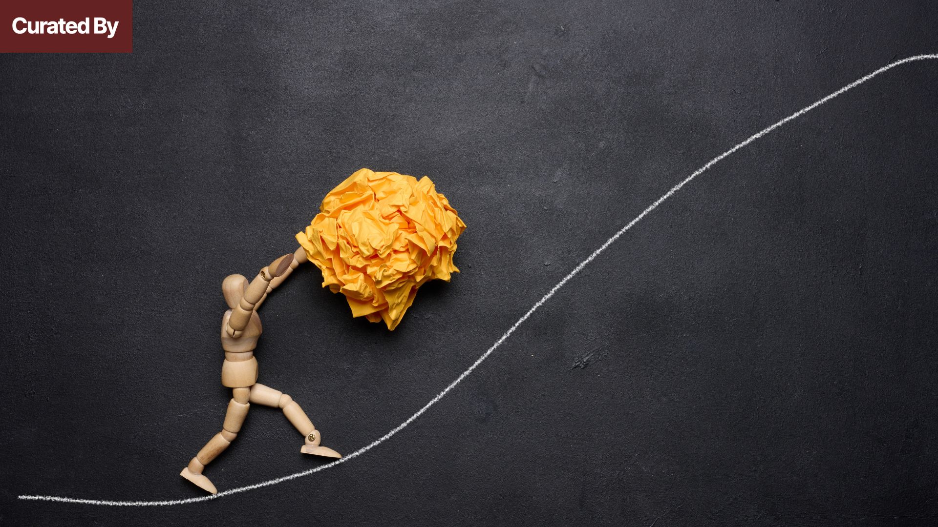 Wooden mannequin pushing a crumpled paper ball uphill on a chalk-drawn slope, representing effort, consistency, and perseverance